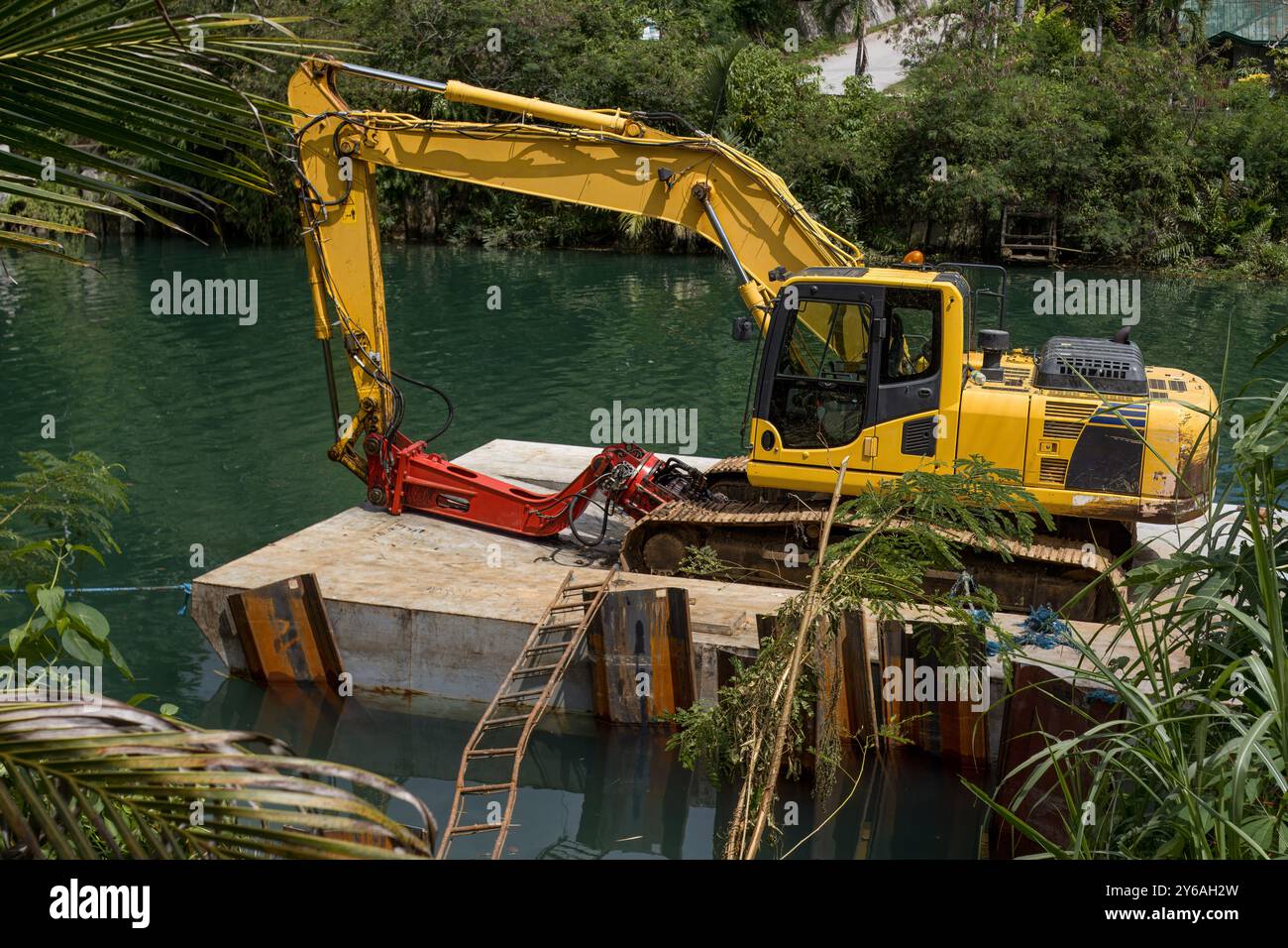 Excavatrice sur une plate-forme flottante, nettoyant et approfondissant la rivière Banque D'Images