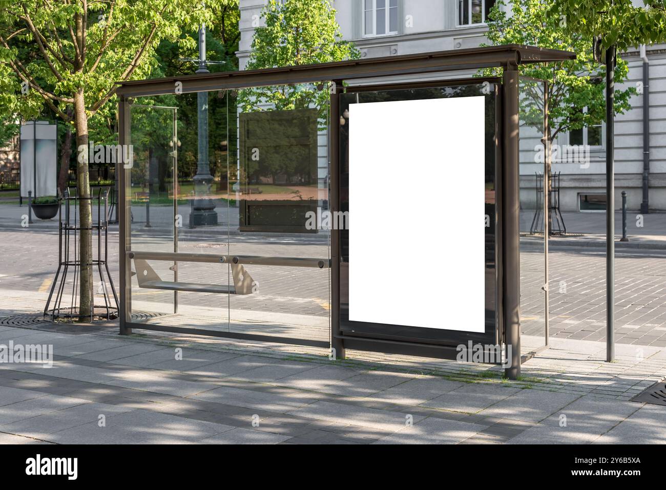 Maquette blanche vierge de panneau vertical d'arrêt de bus devant une rue vide. Visionneuse de publicité extérieure sur le trottoir Banque D'Images