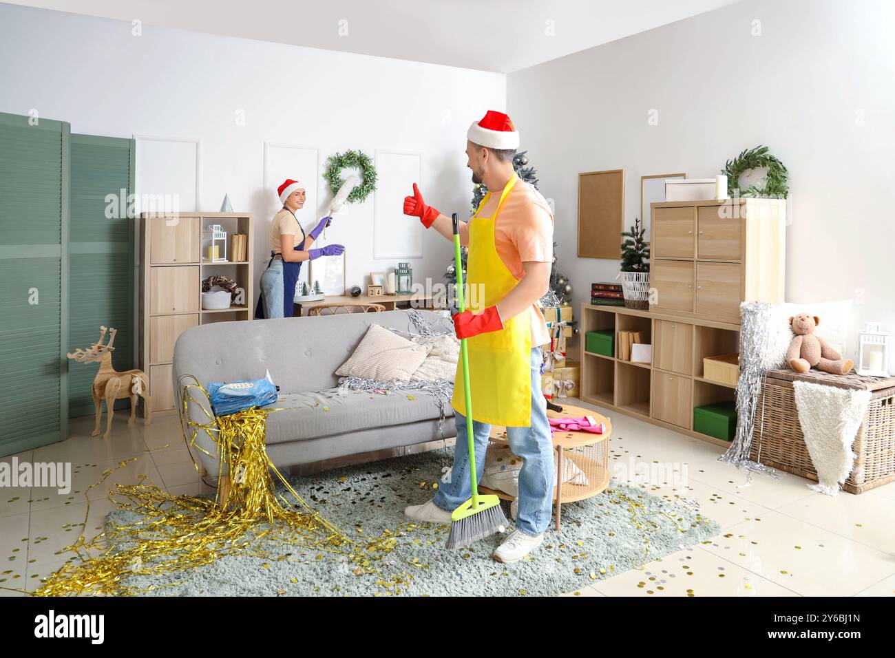 Jeunes concierges dans la salle de nettoyage des chapeaux de Père Noël après la fête du nouvel an Banque D'Images