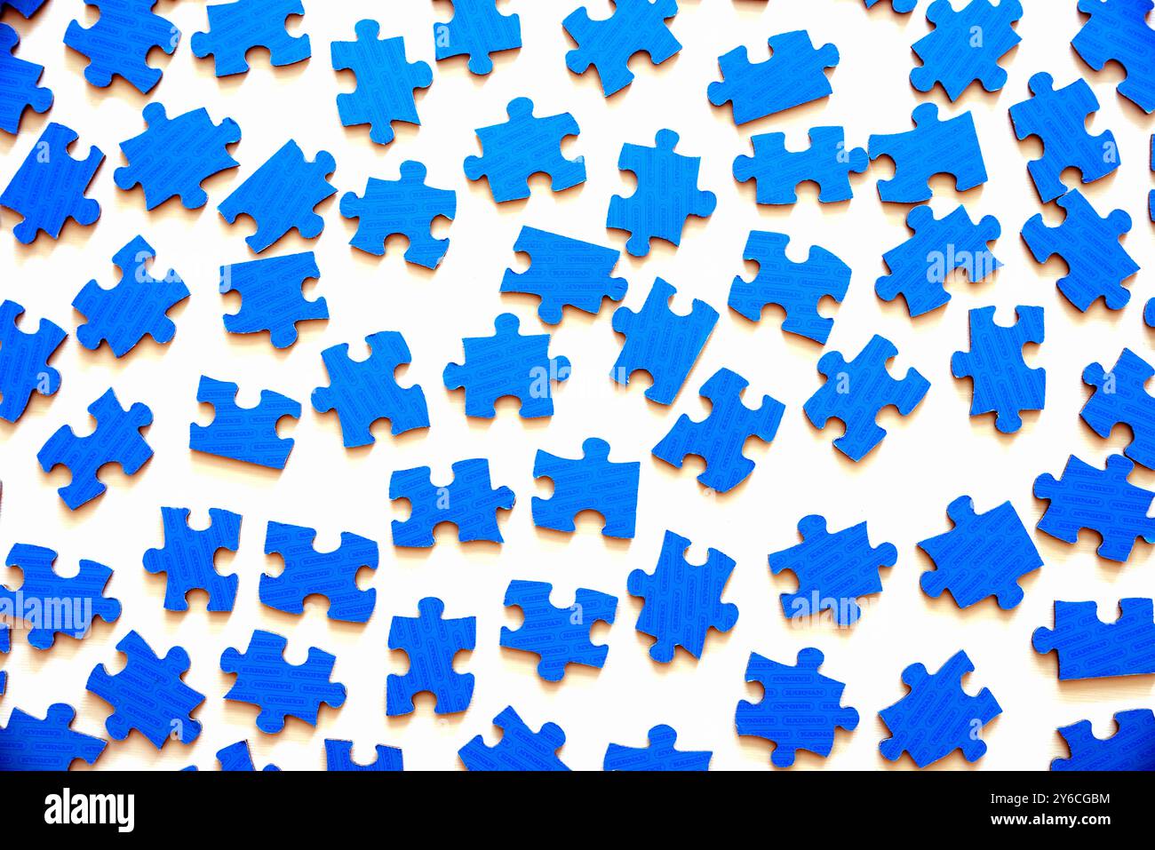 Différents beaucoup de pièces de puzzle bleues sur fond de table blanc Banque D'Images