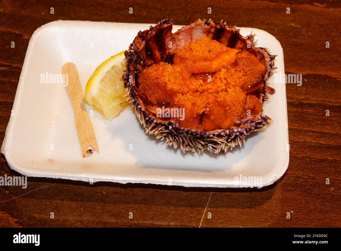 ​​urchin de mer fraîche avec du citron sur une table en bois Banque D'Images