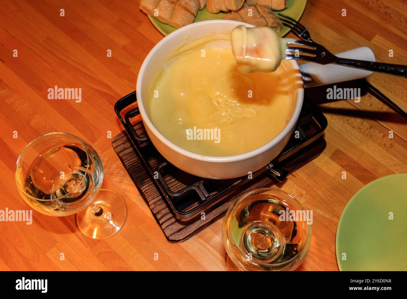 Fondue traditionnelle au fromage et vin sur table en bois. Cuisine suisse Banque D'Images