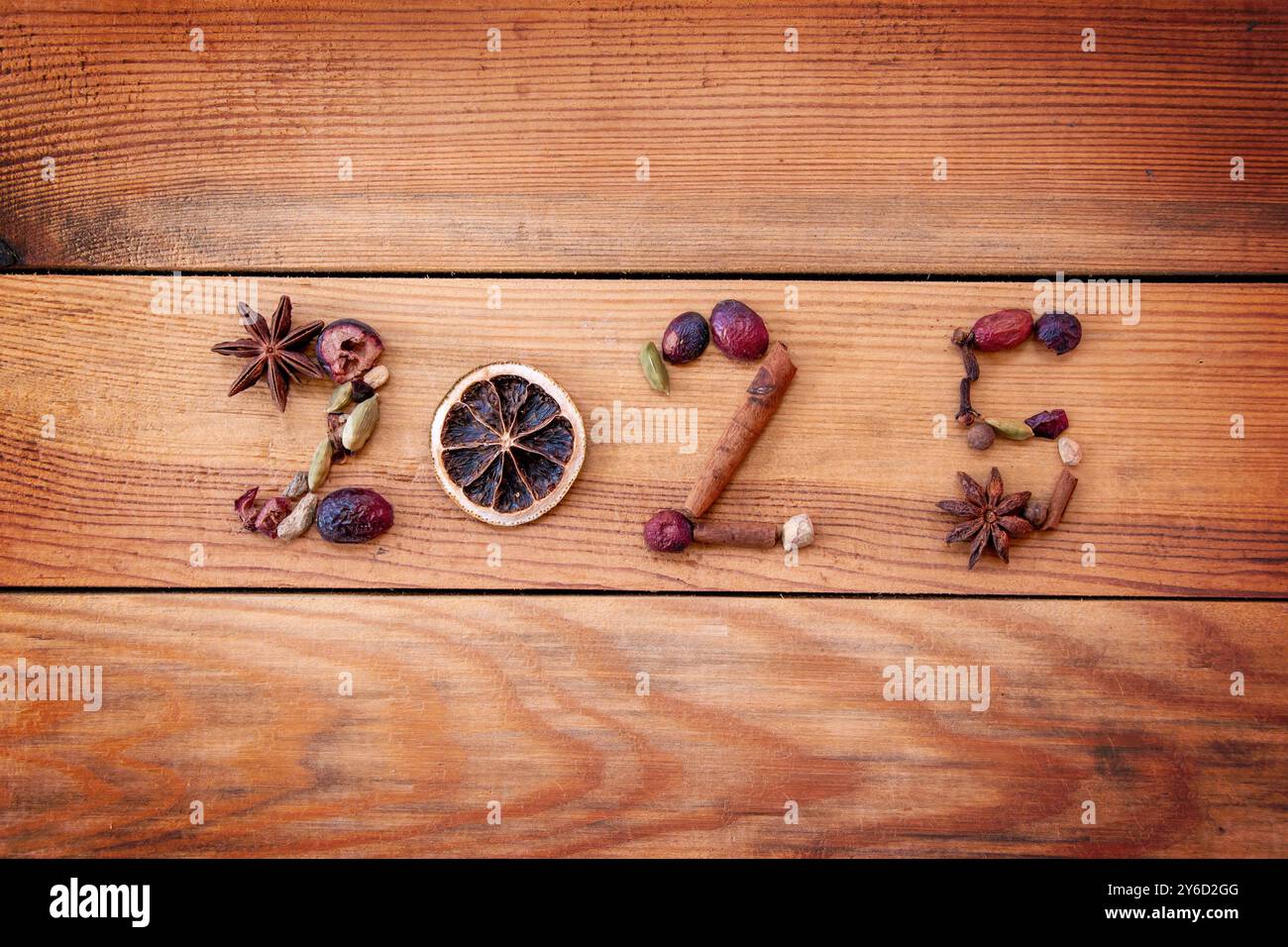 2025 écrit avec des épices de Noël et des fruits secs sur fond en bois, carte de voeux de nouvel an Banque D'Images