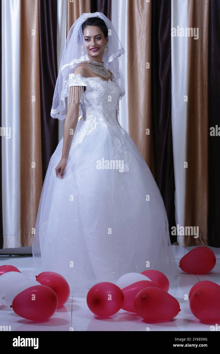 Belle fille blanche robe de mariée Reine bijoux fenêtre extérieure figure Glow Skin Garden Sit Stand Hotel Resort Lights Gardening Female Hostes Banque D'Images