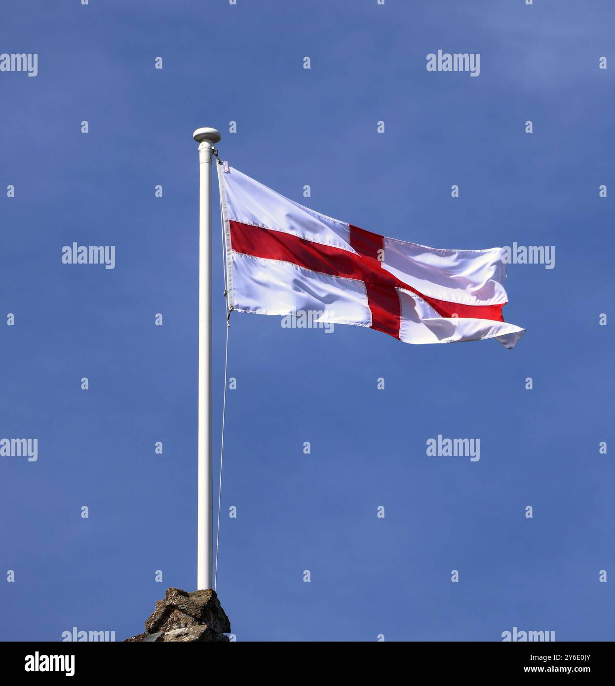 Le drapeau anglais de St George soufflant dans le vent sur un mât de drapeau Banque D'Images
