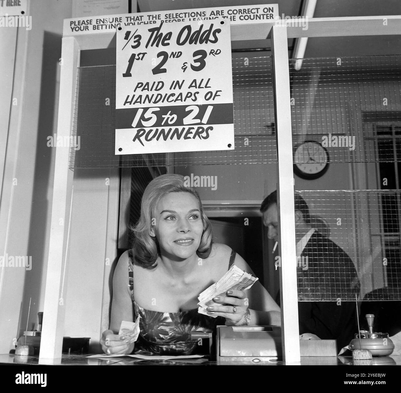 SÉLECTION SOPHISTIQUÉE ! LONDRES, ANGLETERRE, Royaume-Uni : souriant à travers le grill de son magasin de Paris Soho aujourd'hui est Mme Elizabeth Fordham, une ancienne acheteuse de mode à Tanger, dont le père était agent de commission de cours, et qui espère finalement ouvrir une chaîne de 20 magasins de Paris. Mme Fordham est la mère d'une fille de 2 ans. A commenté Mme Fordham, "les hommes ne semblent pas me déranger d'être un bookmaker, et d'autres bookmakers sont tout à fait affables". 21 NOVEMBRE 1962 Banque D'Images SÉLECTION SOPHISTIQUÉE ! LONDRES, ANGLETERRE, Royaume-Uni : souriant à travers le grill de son magasin de Paris Soho aujourd'hui est Mme Elizabeth Fordham, une ancienne acheteuse de mode à Tanger, dont le père était agent de commission de cours, et qui espère finalement ouvrir une chaîne de 20 magasins de Paris. Mme Fordham est la mère d'une fille de 2 ans. A commenté Mme Fordham, "les hommes ne semblent pas me déranger d'être un bookmaker, et d'autres bookmakers sont tout à fait affables". 21 NOVEMBRE 1962 Banque D'Images