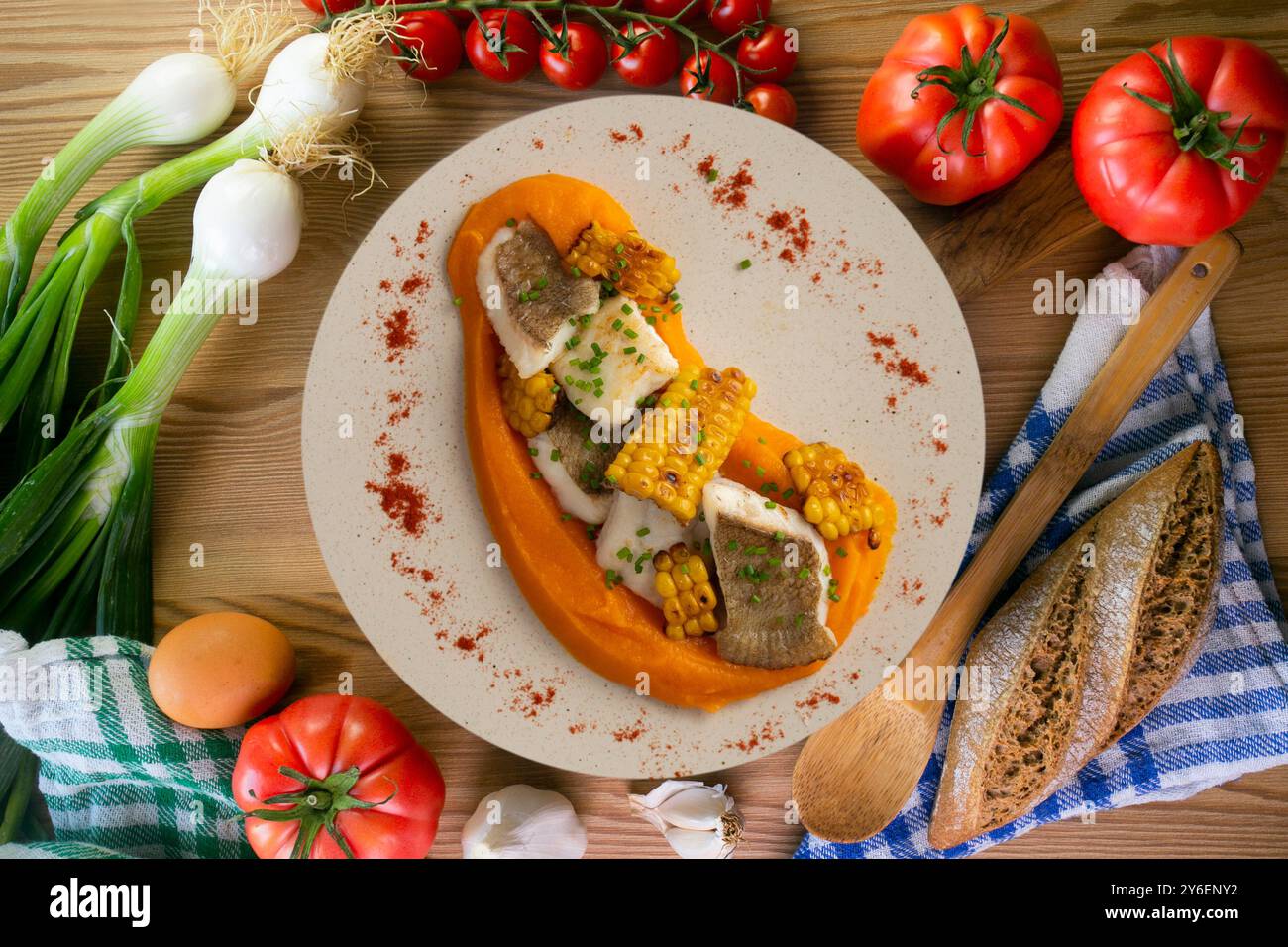 Délicieux poisson de sole avec crème de carottes et maïs. Table vue sur le dessus avec décorations. Banque D'Images