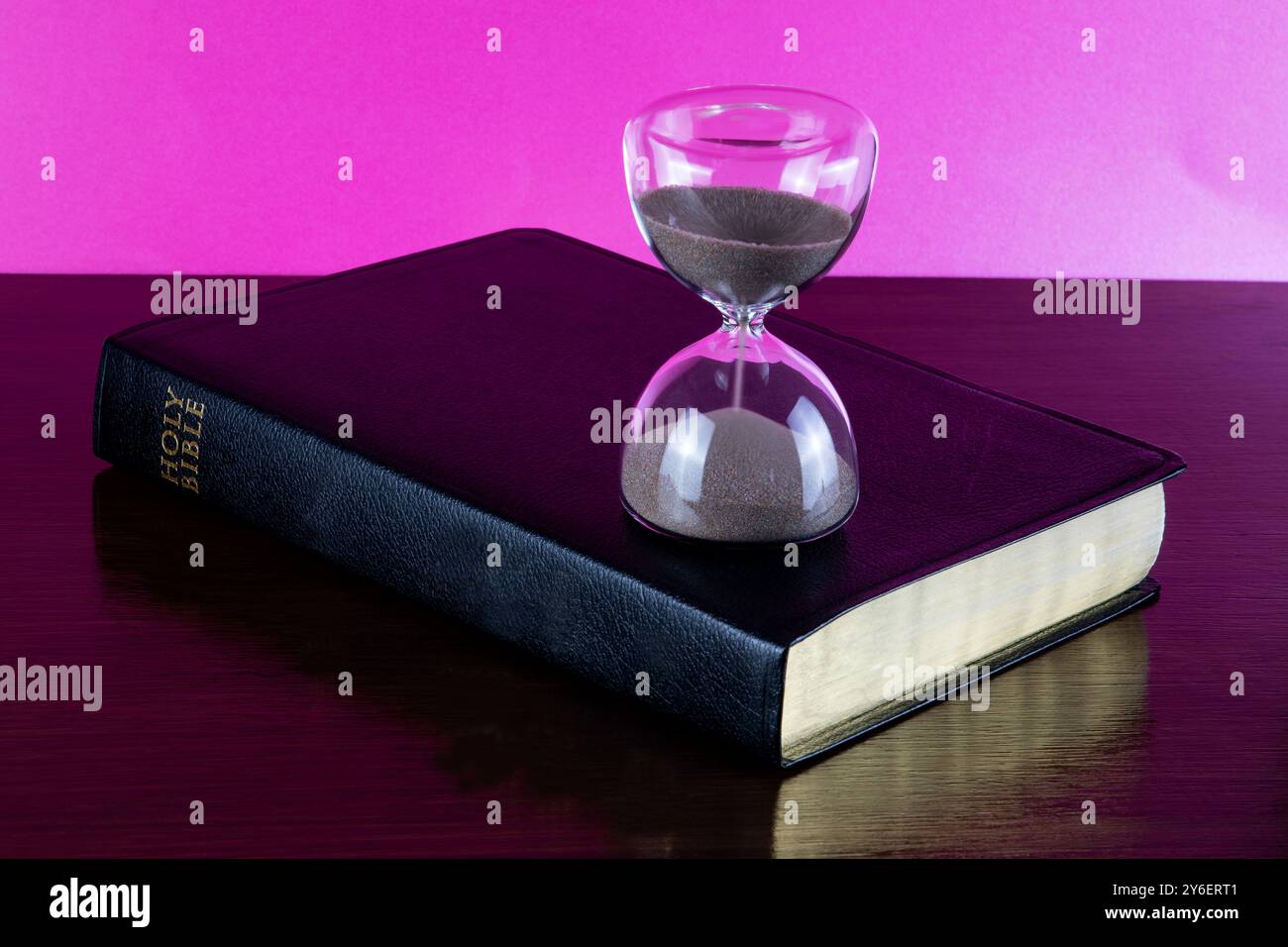 Bible chrétienne sur une étagère en bois poli avec sablier en verre Banque D'Images
