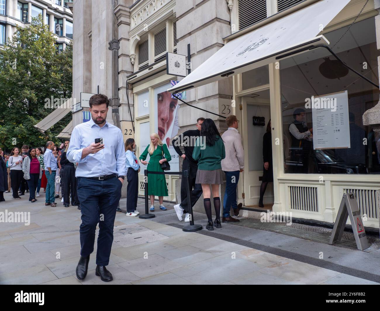 Les files d'attente des gens font la queue à l'extérieur, la Salad Kitchen pour le déjeuner à emporter, alors que les gens retournent au travail après le confinement Banque D'Images