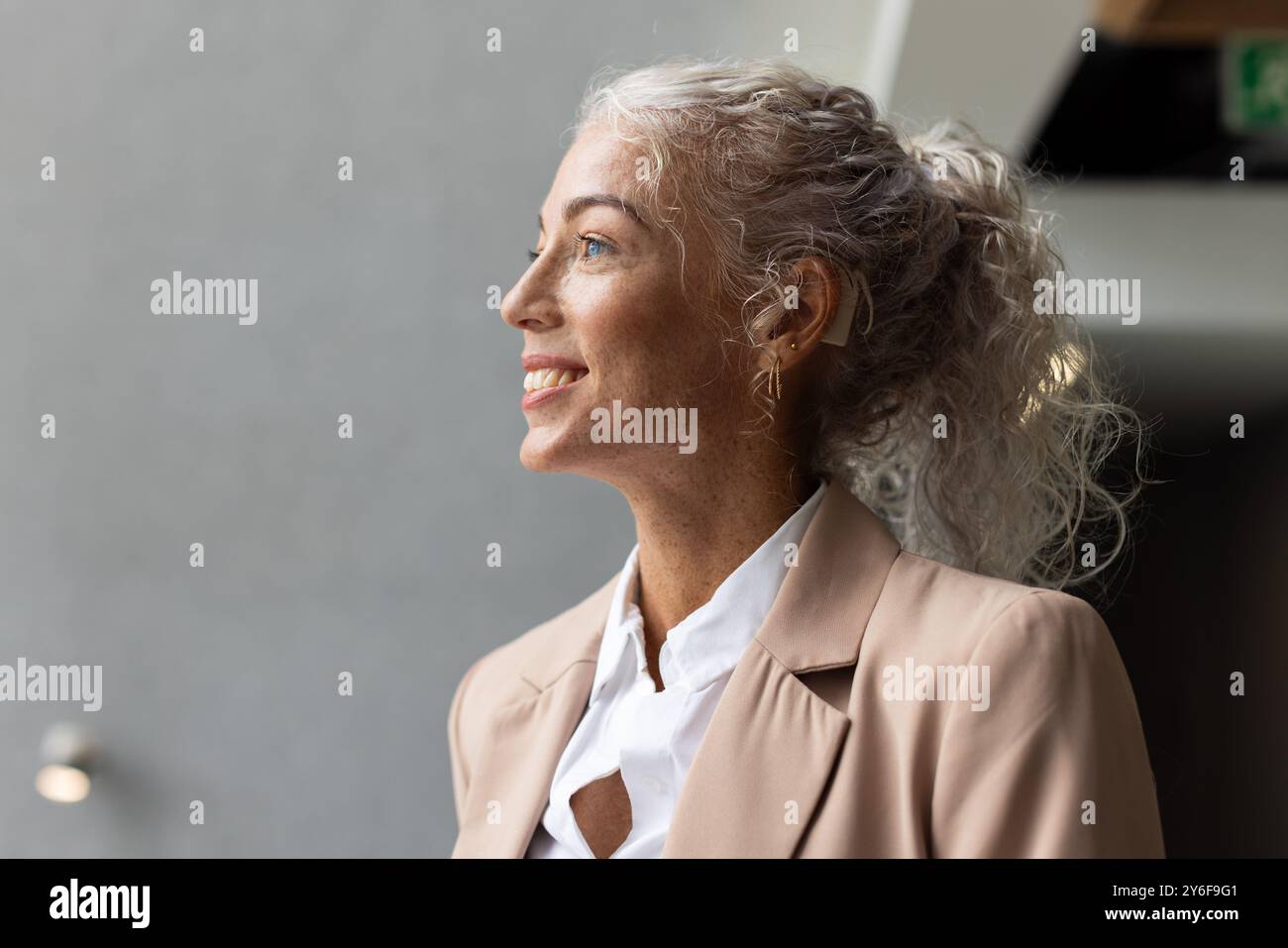 Se sentir confiant, souriante femme d'affaires en tenue professionnelle regardant loin Banque D'Images