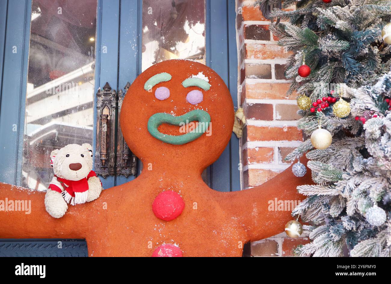Énorme figure d'homme en pain d'épice et adorable peluche ours polaire avec arbre de Noël Banque D'Images