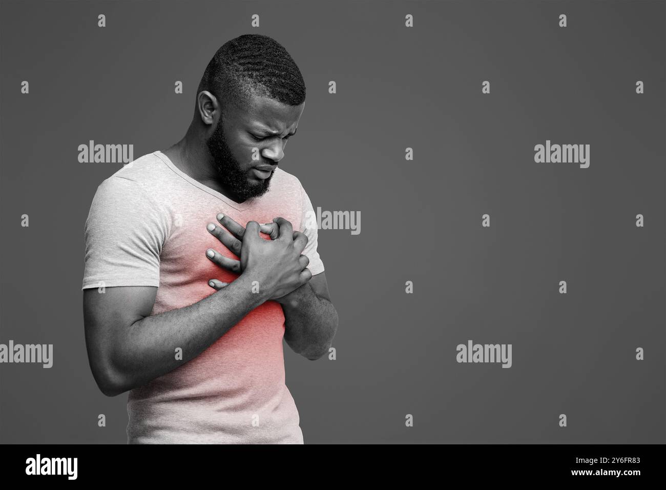 Triste jeune homme afro frottant sa poitrine Banque D'Images