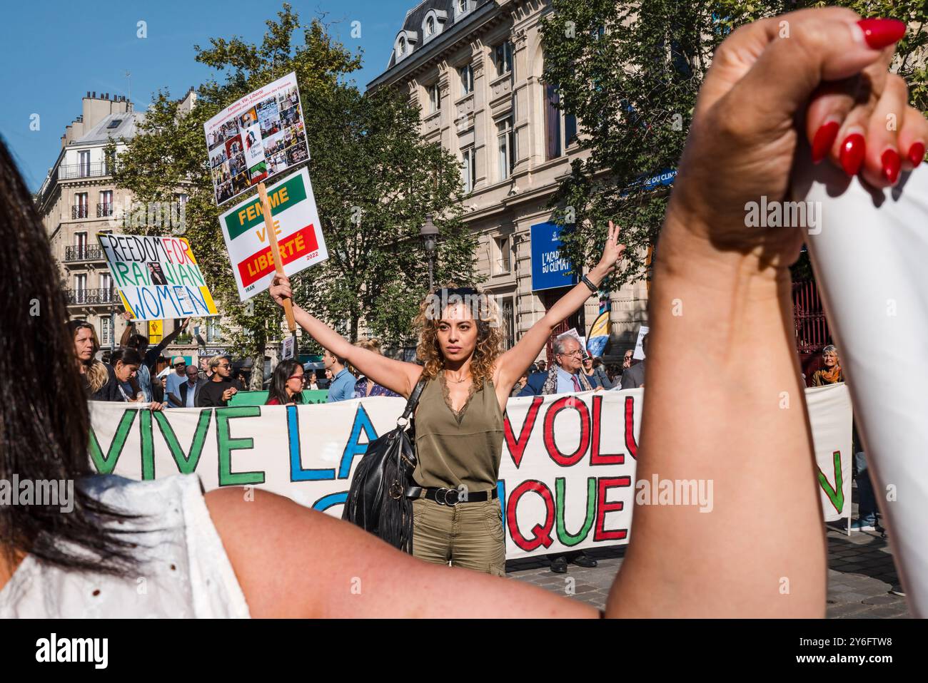 Une femme à la fin de la manifestation avec une pancarte, Woman Life Free, un mouvement international pour l émancipation des femmes. Devant la bannière, vive la Révolution démocratique en Iran. Femme liberté de vie. Manifestations pour marquer le 2e anniversaire de l’assassinat de Jina Mahsa Amini le 16 septembre 2022 à Téhéran, et pour soutenir le peuple iranien dans sa quête de liberté, de laïcité et de démocratie. France, Paris, 15 septembre 2024. Photo de Patricia Huchot-Boissier / Agence DyF. Banque D'Images