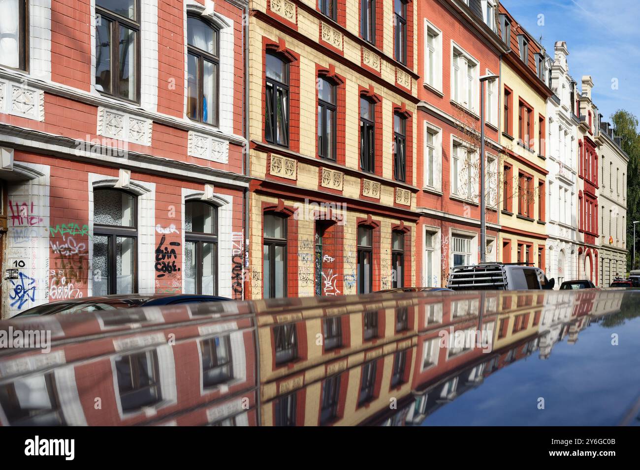 une longue rangée de maisons ouvrières simples typiques de l'époque fondatrice dans des couleurs pastel chaudes à cologne ehrenfeld Banque D'Images