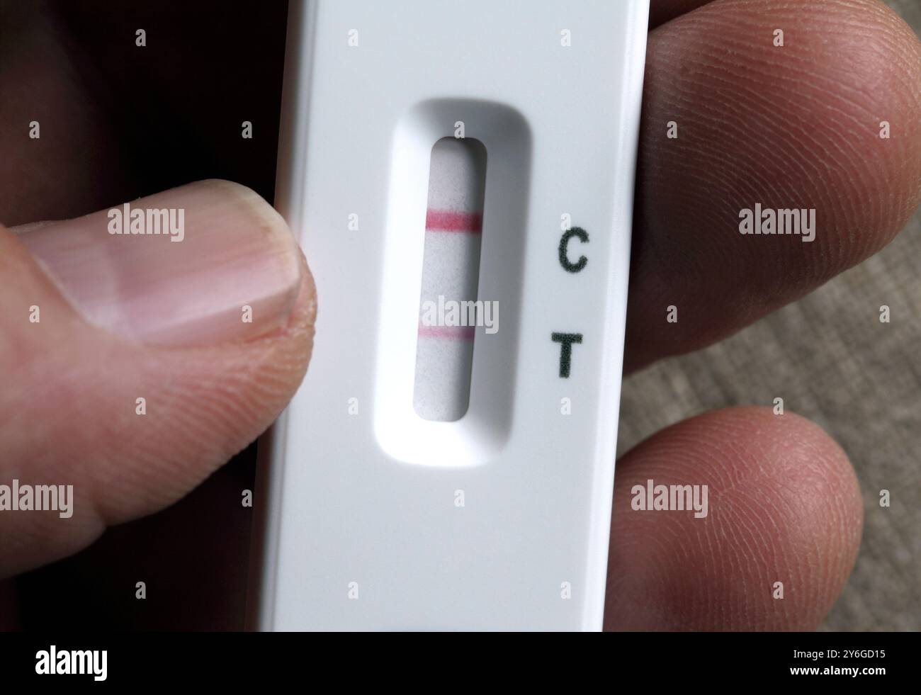 Une faible ligne rouge indique un résultat positif d’un test de flux latéral covid. Banque D'Images