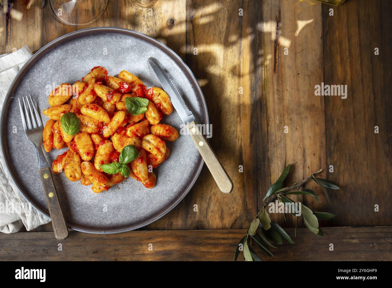 Nourriture, nourriture, gnocchi traditionnel de pomme de terre italienne avec sauce tomate et basilic frais sur plaque bleue sur fond de bois Banque D'Images