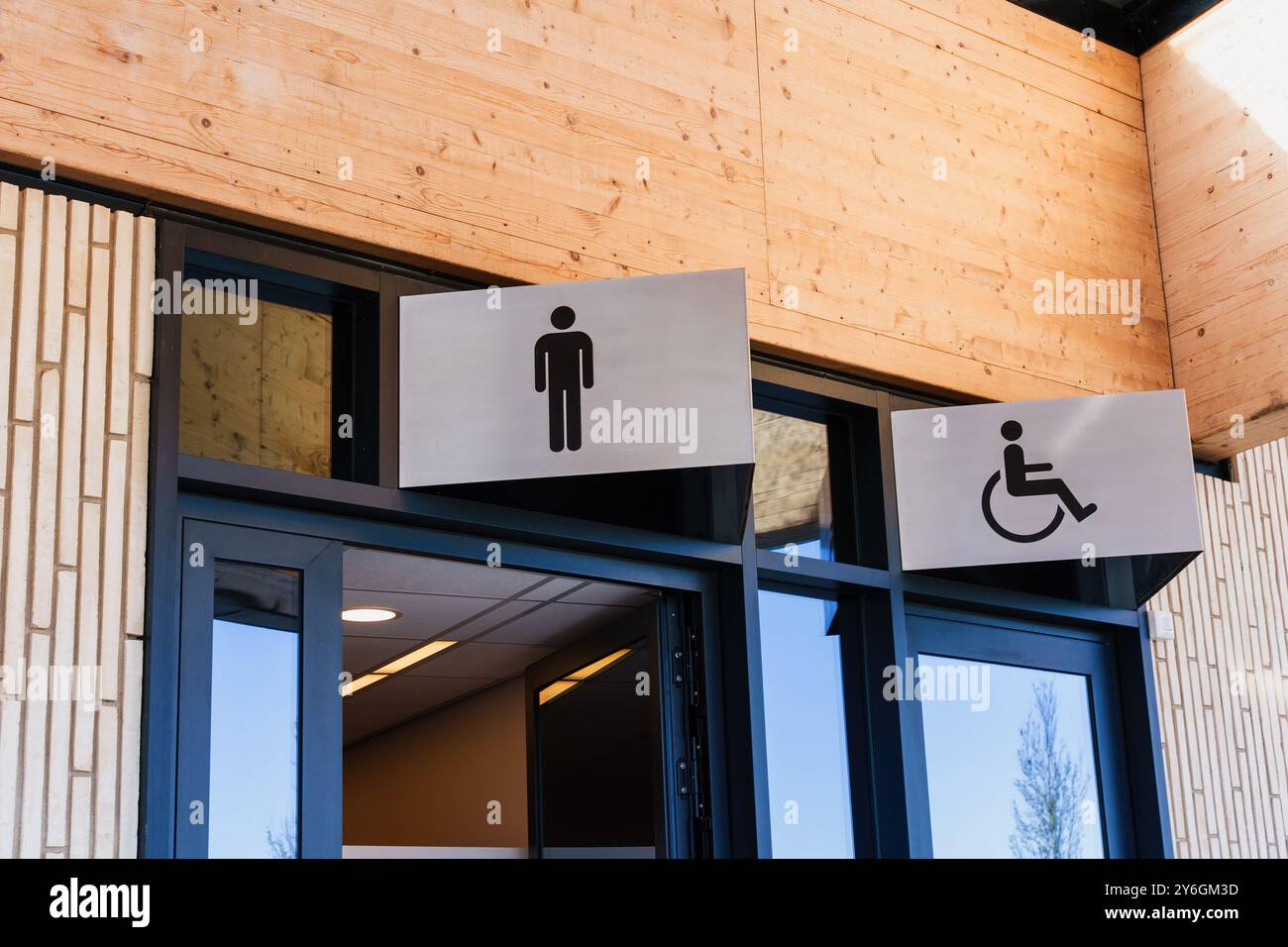 Entrée moderne des toilettes publiques avec deux panneaux de toilettes, un pour les hommes et un pour l'accessibilité Banque D'Images