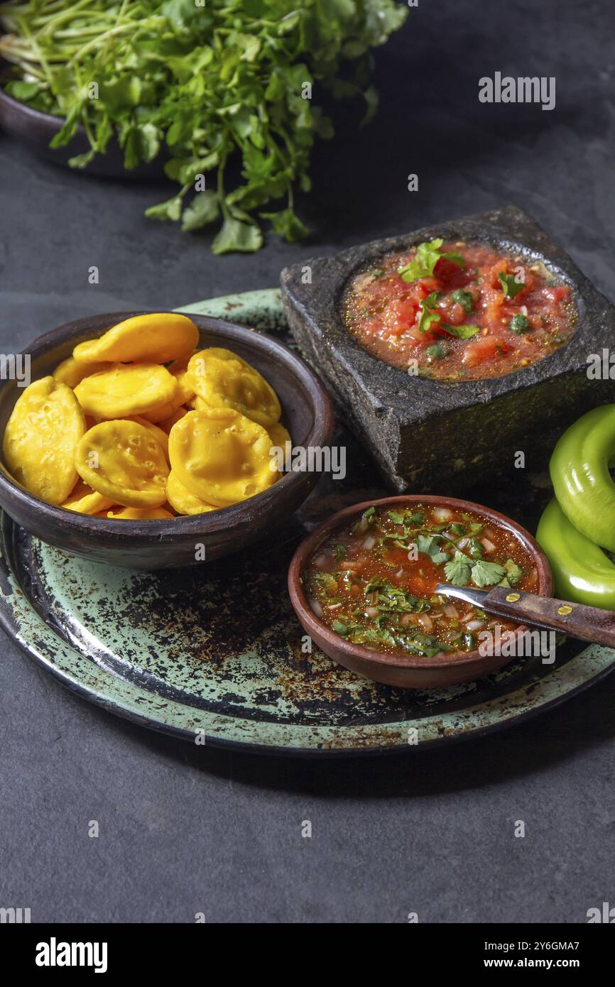 Nourriture, Sopaipilla. Cuisine latino-américaine. Sopaipillas de citrouille maison traditionnelle chilienne avec salsas typiques, sauce tomate chancho en piedra dans la pierre m Banque D'Images