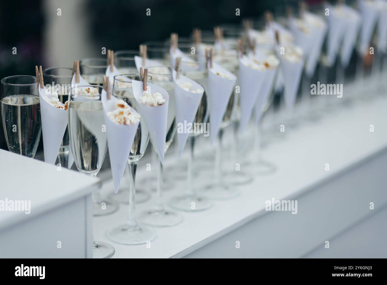 Verres avec du vin mousseux froid debout sur un comptoir dans une rangée, piscine à l'arrière, bar de fête Banque D'Images