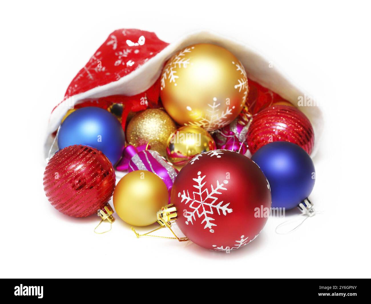 Boules de noël lumineuses, jouets dans le chapeau rouge du Père Noël sur fond blanc Banque D'Images