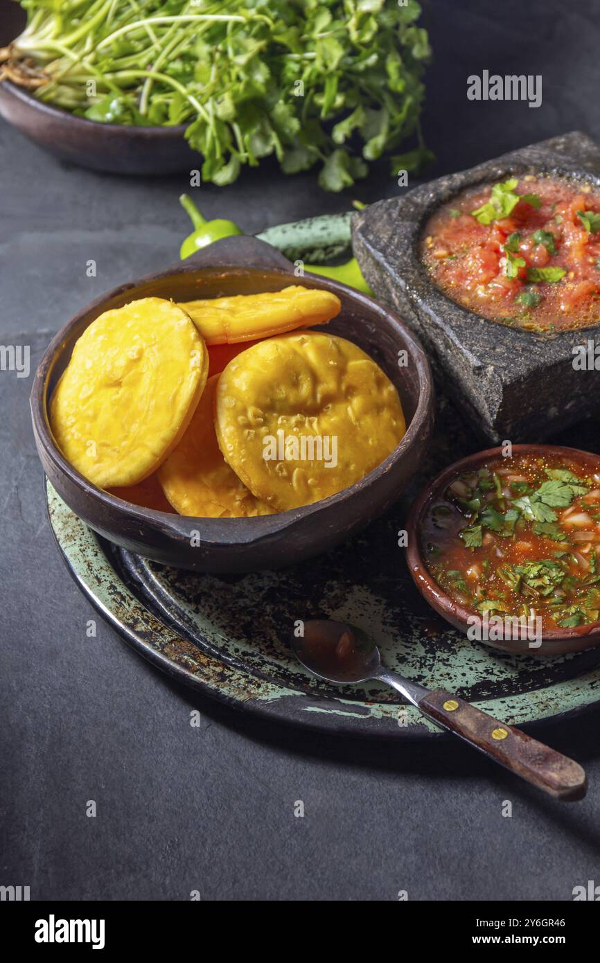 Nourriture, Sopaipilla. Cuisine latino-américaine. Sopaipillas de citrouille maison traditionnelle chilienne avec salsas typiques, sauce tomate chancho en piedra dans la pierre m Banque D'Images