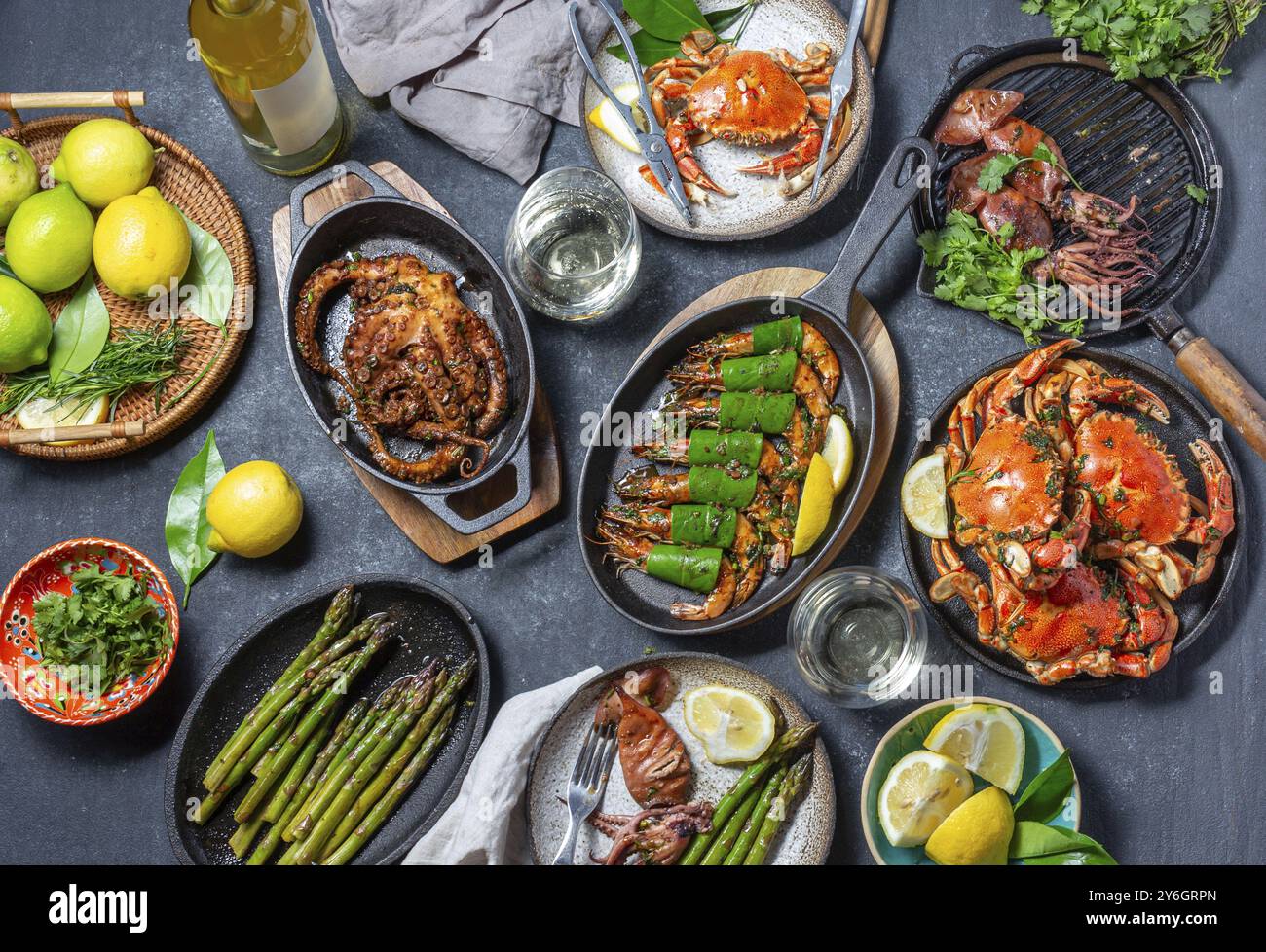 Nourriture, nourriture, set table avec des plats de fruits de mer, crabes cuits, crevettes tigrées, poulpe grillé et calmars sur des poêles grillées en fonte et des assiettes, vin blanc. T Banque D'Images