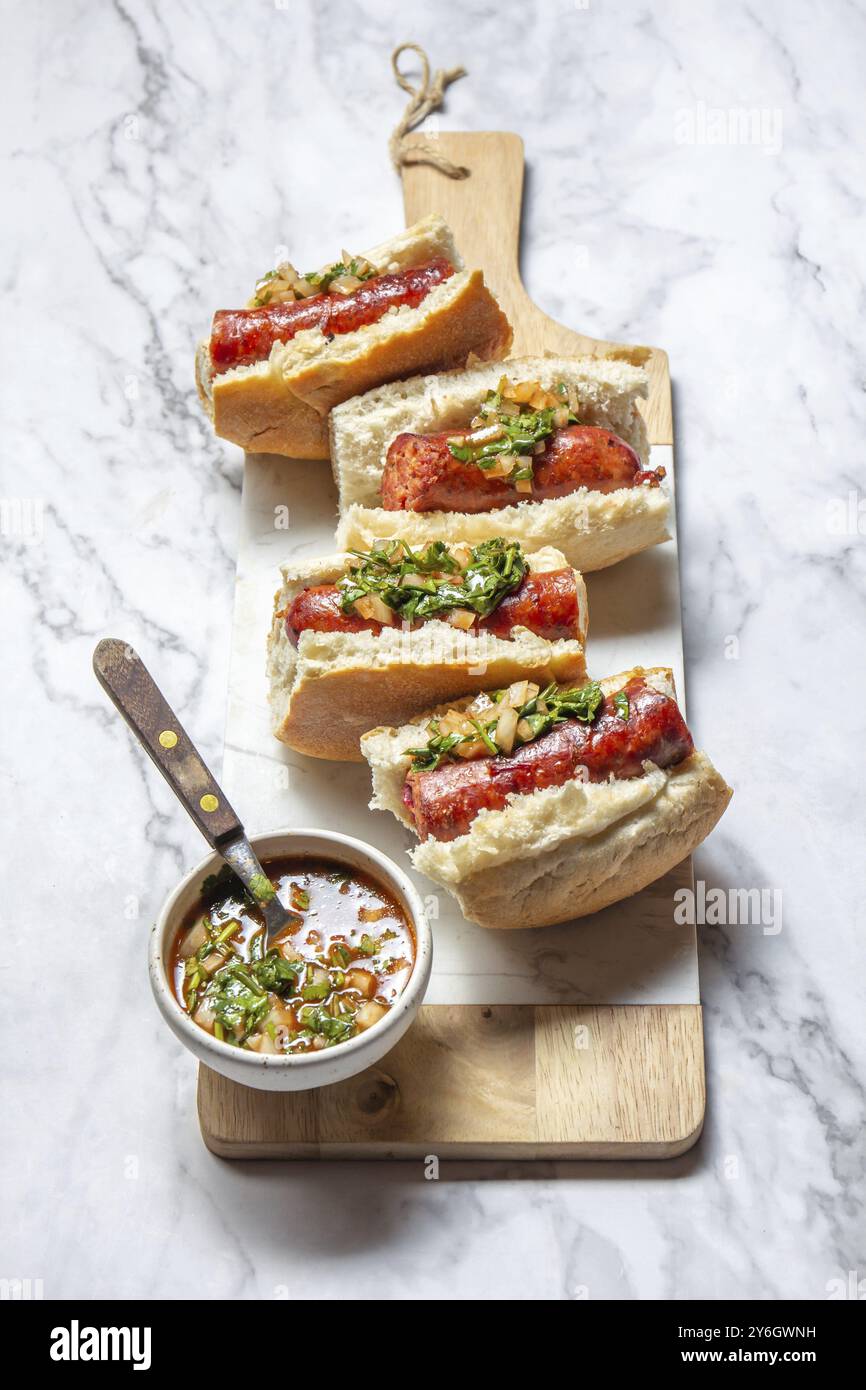 Nourriture, cuisine chilienne et Argentine. Choripan traditionnel avec pebre épicé, sandwich au chorizo avec saucisses au chorizo et pain Banque D'Images