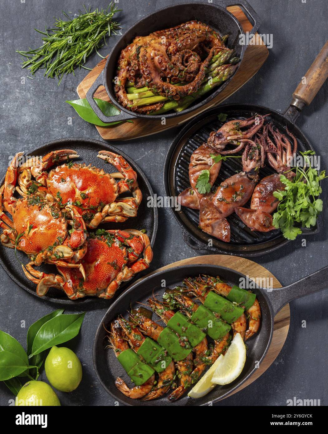 Nourriture, table avec plats de fruits de mer, crabes cuits, crevettes tigrées, poulpes grillés et calmars sur une poêle en fonte Banque D'Images