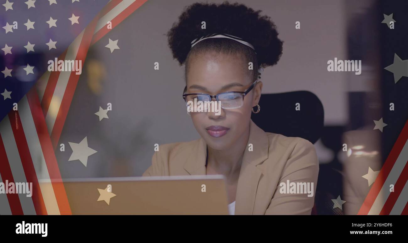 Image du drapeau des états-unis sur la femme d'affaires afro-américaine heureuse à l'aide d'un ordinateur portable Banque D'Images