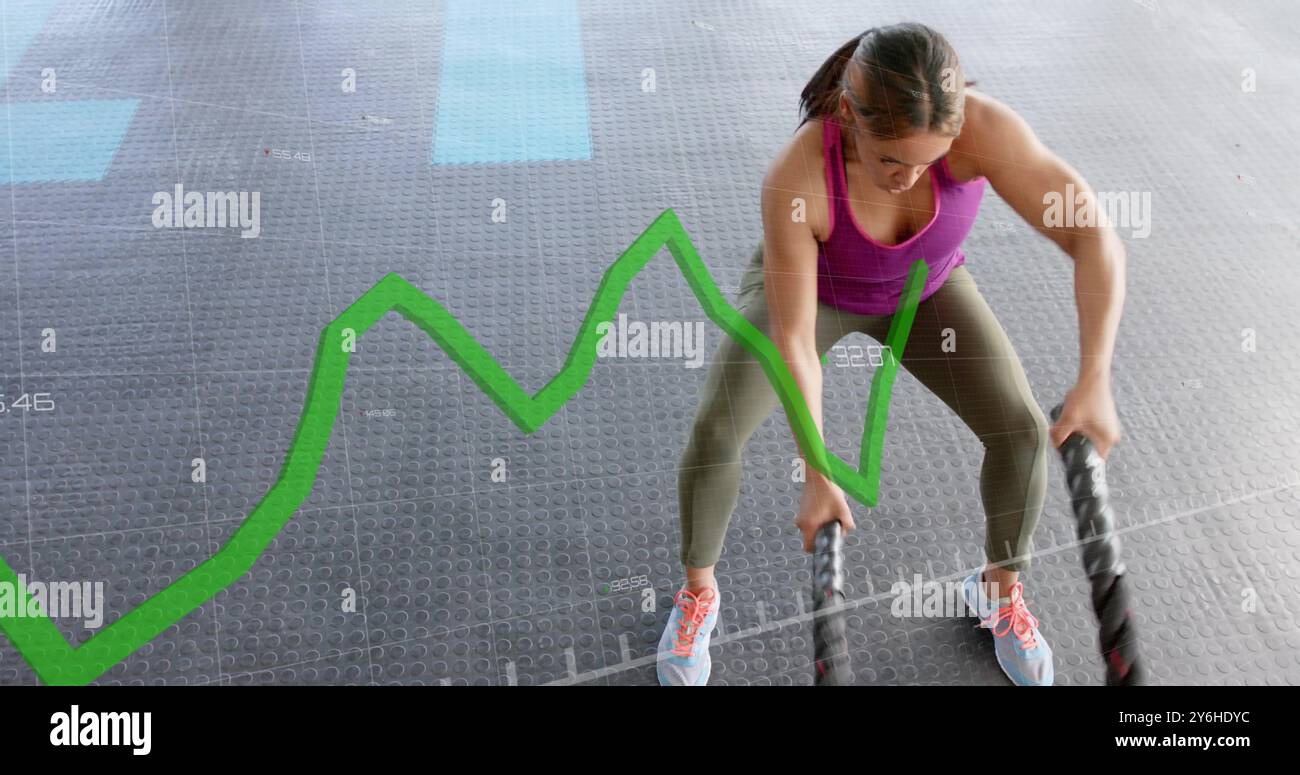 Image graphique de ligne verte sur la femme exerçant avec des cordes de combat dans le gymnase Banque D'Images
