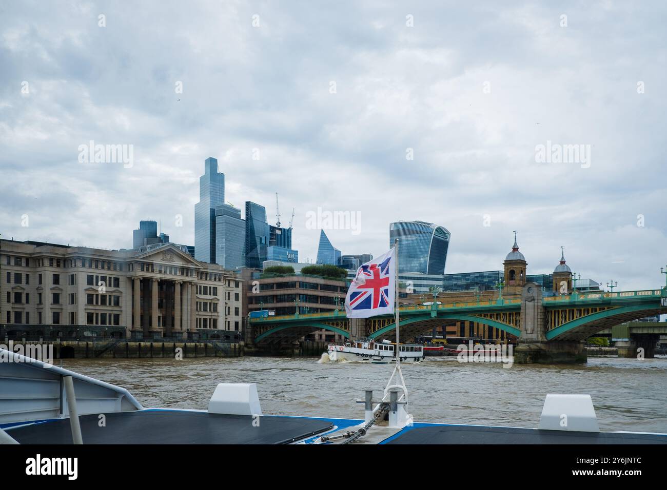 Promenade en bateau sur la Tamise en direction du pont Southwark. Drapeau de la Grande-Bretagne agitant. Drapeau du Royaume-Uni dans le vent. Tourisme à Londres. En déplacement Banque D'Images