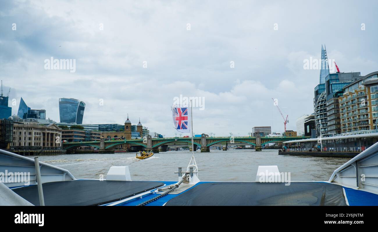 Promenade en bateau sur la Tamise en direction du pont Southwark. Drapeau de la Grande-Bretagne agitant. Drapeau du Royaume-Uni dans le vent. Tourisme à Londres. En déplacement Banque D'Images