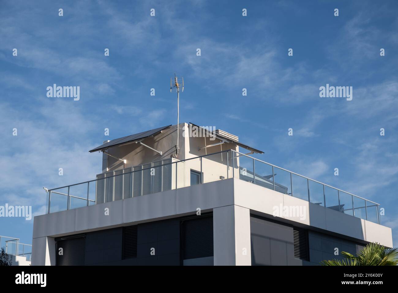 vue latérale d'une maison individuelle d'architecture moderne avec une installation de panneaux solaires photovoltaïques avec une rampe en verre léger. La journée est ensoleillée. Co Banque D'Images