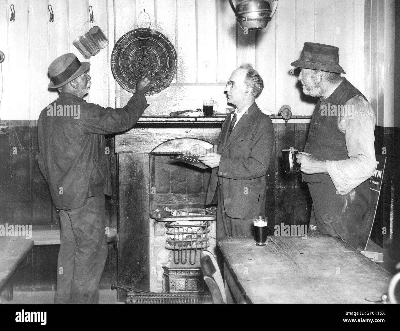 Rural Angleterre dans la salle de robinet de la Spread Eagle Inn à Little Bardfield dans l'Essex est Moses drain the thatcher , Harry Barnes , le propriétaire et Charles (uppy) Andrews la verrue curer 1937 Banque D'Images