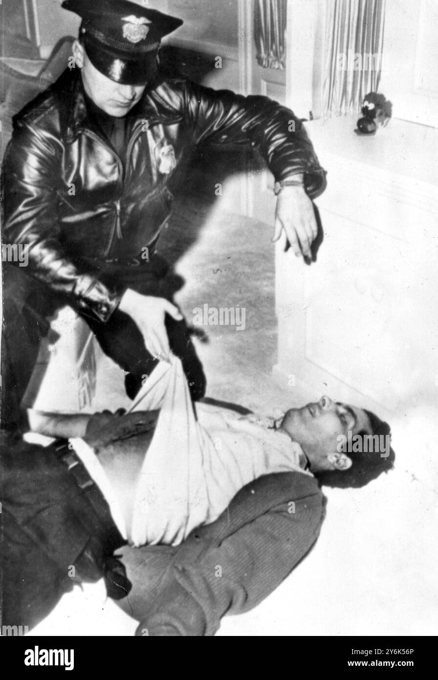 Beverly Hills , Californie Etats-Unis Johnny Stompanato poignardé à mort par la fille de 14 ans de Lana Turner . Johnny Stompanato corps sur le sol de la chambre de l'actrice Lana Turner . Agent de police de Beverly Hills examinant le cadavre. 1958 Banque D'Images