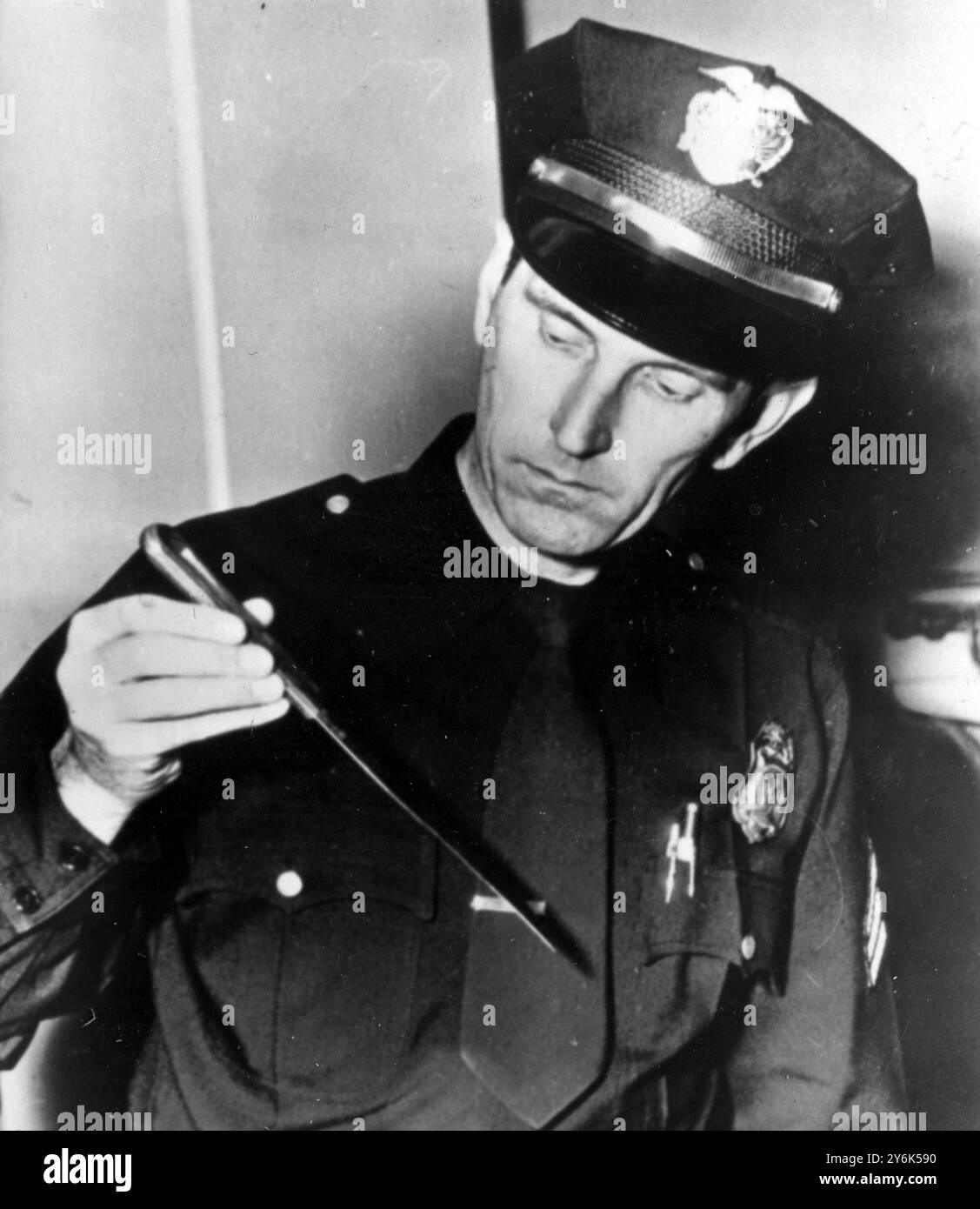 Los Angeles , Californie Etats-Unis Johnny Stompanato poignardé à mort par la fille de 14 ans de Lana Turner . Cheryl Crane, fille de son précédent mariage, a été accusée de meurtre. Beverly Hills police Sgt Russell R . Peterson tenant le couteau de 10 pouces utilisé pour le poignarder à mort 1958 Banque D'Images