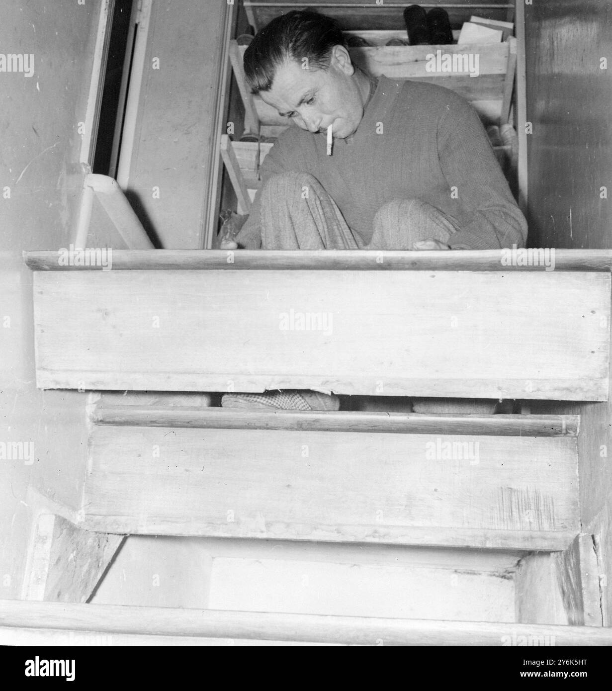 Ancien déserteur GI il y a 14 ans Wayne Powers de Missouri USA 37 ans est détenu par les autorités militaires américaines en attendant l'enquête la raison de la désertion est qu'il est tombé amoureux de la jeune fille française Yvette Beleuse avec qui il vit avec quatre enfants vivant maintenant à Mont Dorigny . Cachette sous les escaliers où les pouvoirs se cachaient quand le danger menaçait. La marche supérieure est mobile et lorsqu'elle est retournée après que les pouvoirs se soient serrés dans la cachette qui est de 14 pouces par 16 pouces par 37 pouces, les escaliers ont pris leur apparence solide et permanente. 25 mars 1958 Banque D'Images