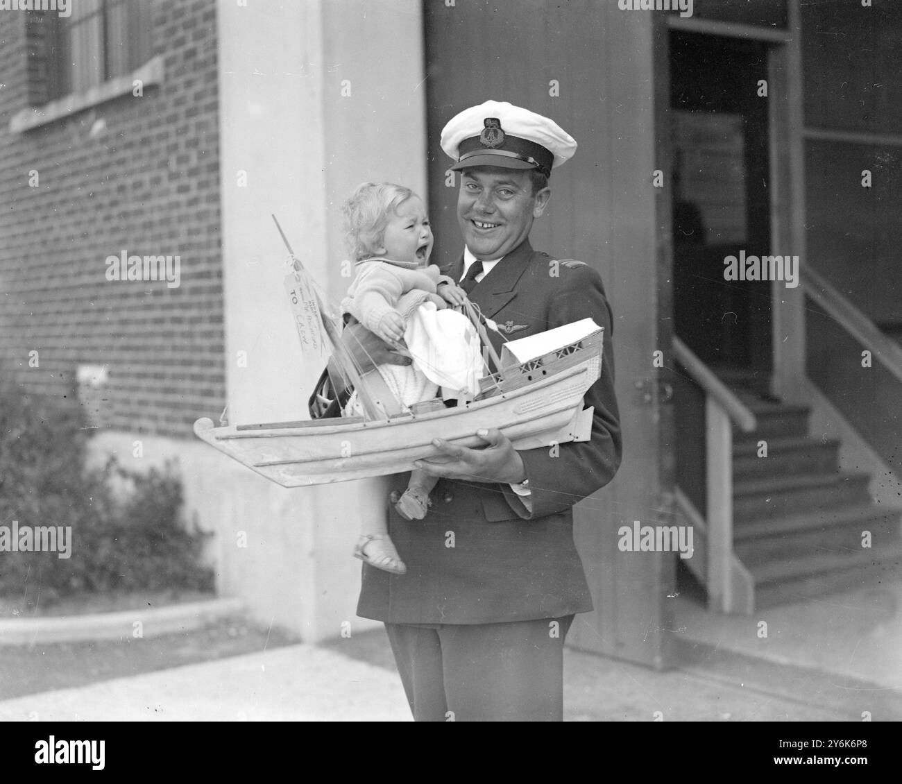 Southampton Capitaine R . Parker ( Imperial Airways ) avec Christine Johnson, 13 mois, qu'il a ramenée de Bassorah , elle aussi modèle d'un spectacle d'Afrique de l'est , sur l'hydravion 'Calypso' le 31 mai 1939 Banque D'Images