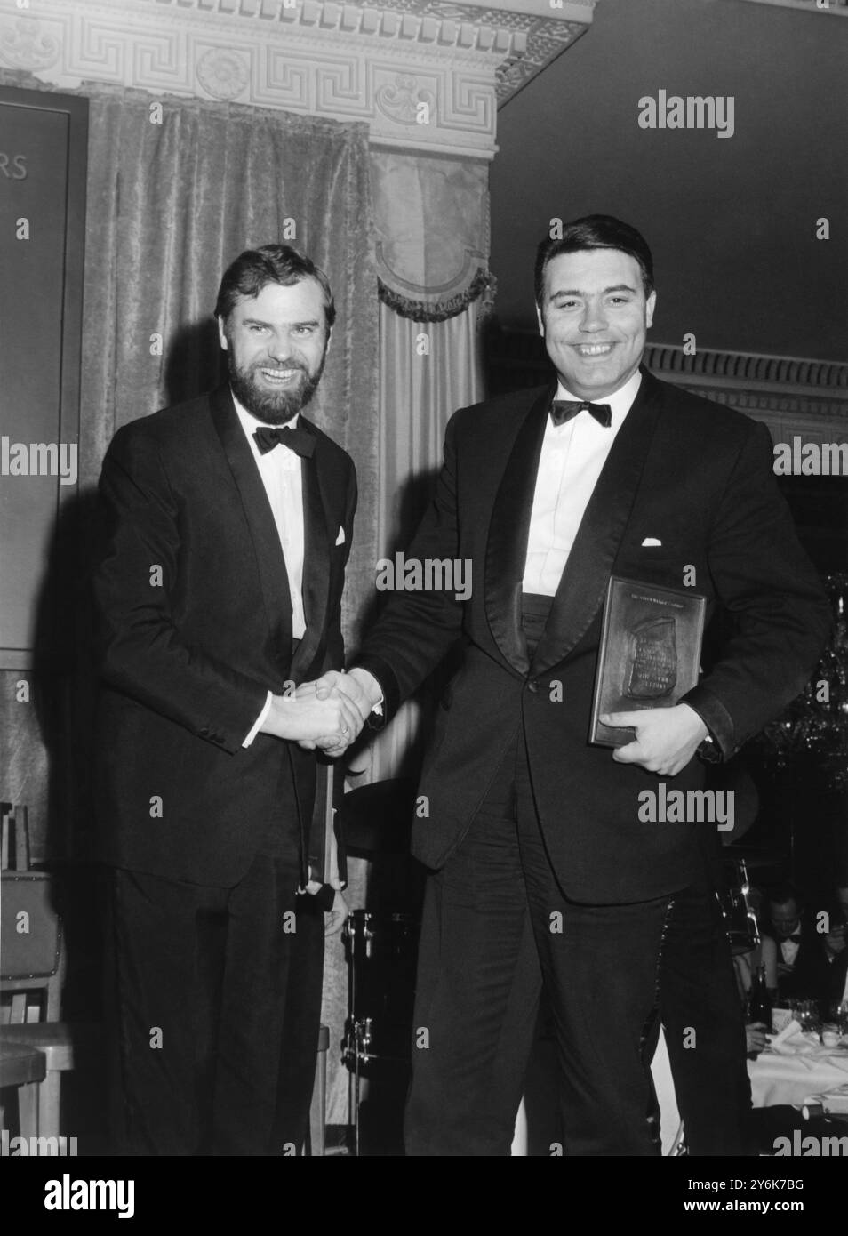 Les scénaristes Ray Galton (à gauche) et Alan Simpson se félicitent mutuellement lors du dîner Screen Writers Guild Award à l'hôtel Dorchester de Londres, où ils ont reçu de Lord Willis , le Prix de la série ou série British Light Entertainment, en direct ou filmé, le 12 mars 1964 Banque D'Images