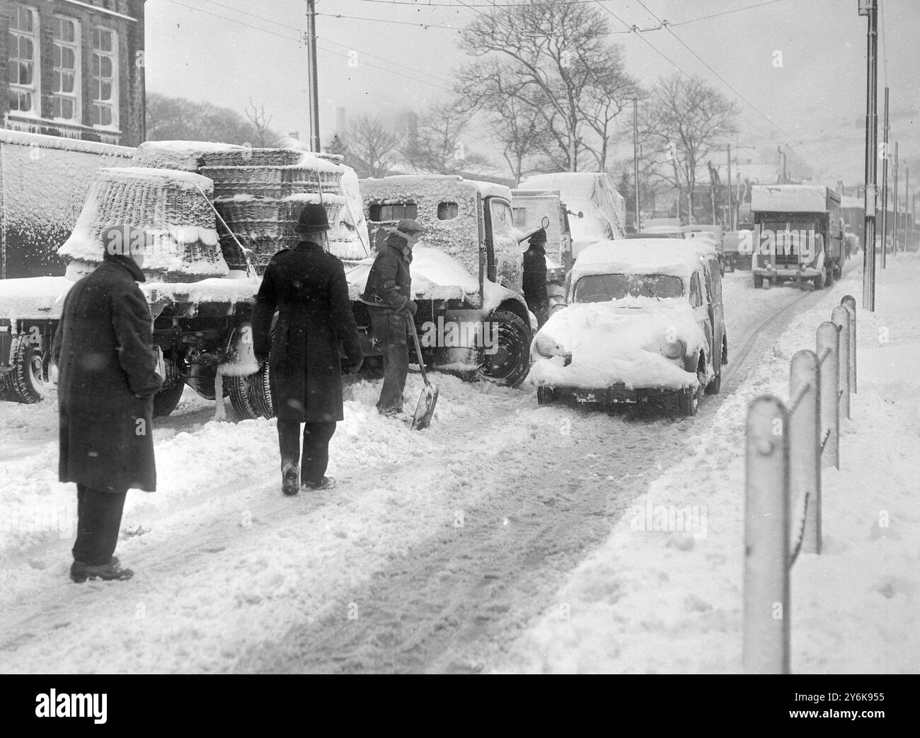 Angleterre frappée par le blizzard de neige certains des 500 camions de transport lourds échoués à Marsden sur le côté Yorkshire de Standedge qui est bloqué par des dérives de 20 pieds de profondeur le 26 février 1958 Banque D'Images