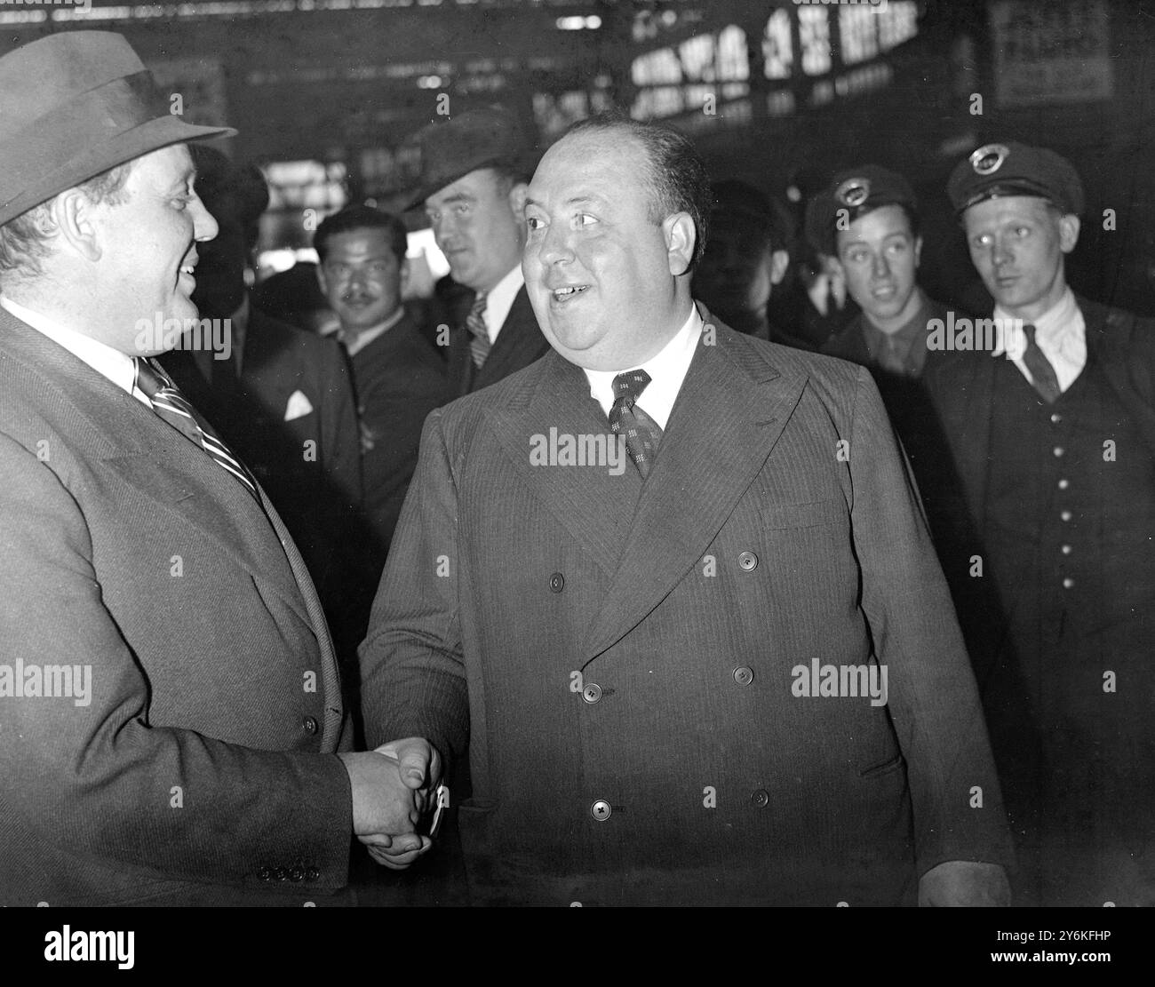 À Waterloo Station - Charles Laughton (1er juillet 1899-15 décembre 1962) acteur de scène et de cinéma anglais, scénariste, producteur et réalisateur. Et - Alfred Hitchcook - Sir Alfred Joseph Hitchcock, KBE (13 août 1899 - 29 avril 1980) était un réalisateur et producteur américain d'origine anglaise emblématique et très influent qui a été le pionnier de nombreuses techniques dans les genres suspense et thriller. 18 juillet 1938 © TopFoto Banque D'Images