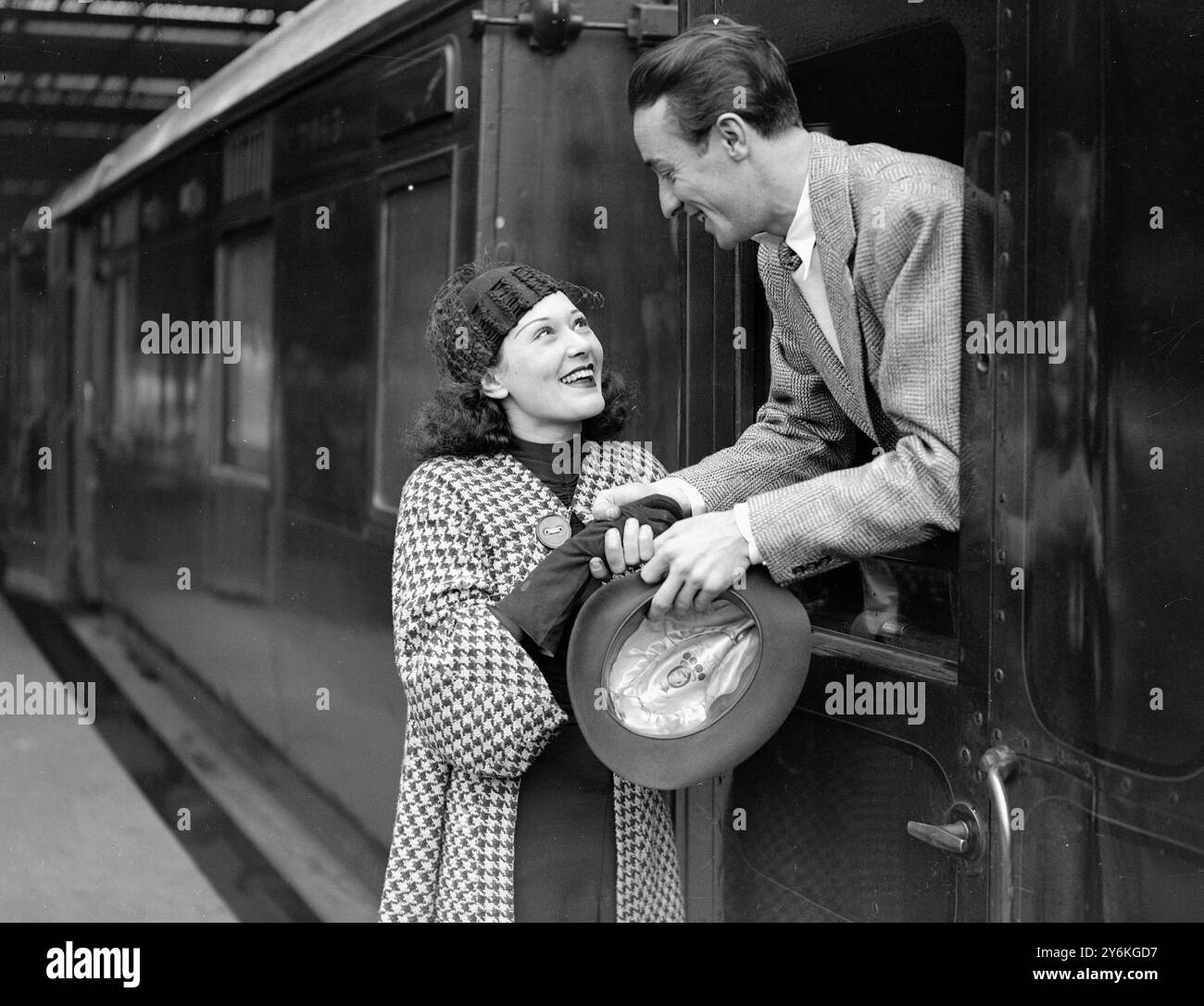 A Waterloo Station - Miss Chili Bouchier, la star de cinéma anglaise, fait ses adieux à Teddy Joyce, le chef d'orchestre, à l'occasion du départ de ce dernier pour l'exposition Empire à Johannes-burg 21 août 1936 © TopFoto Banque D'Images