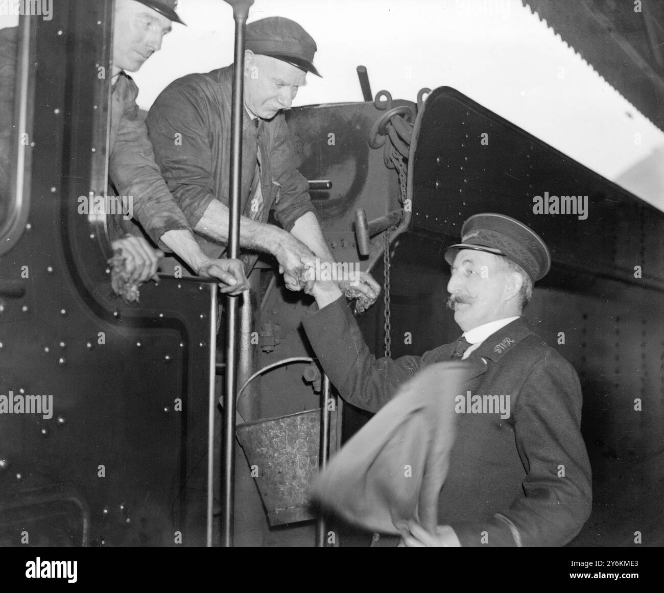 Paddington. Le gardien Edward Hurley, pendant 43 ans l'un des gardes passagers les plus âgés du Great Western Railway et habituellement associé aux trains transportant des membres de la famille royale, est félicité pour avoir reçu la médaille O.B.E., Un honneur du nouvel an en lien avec le centenaire du Great Western Railway. 1er janvier 1936 Banque D'Images