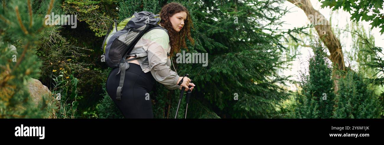 Une femme de taille plus confiante profite d'une promenade paisible dans une forêt vibrante entourée de verdure. Banque D'Images