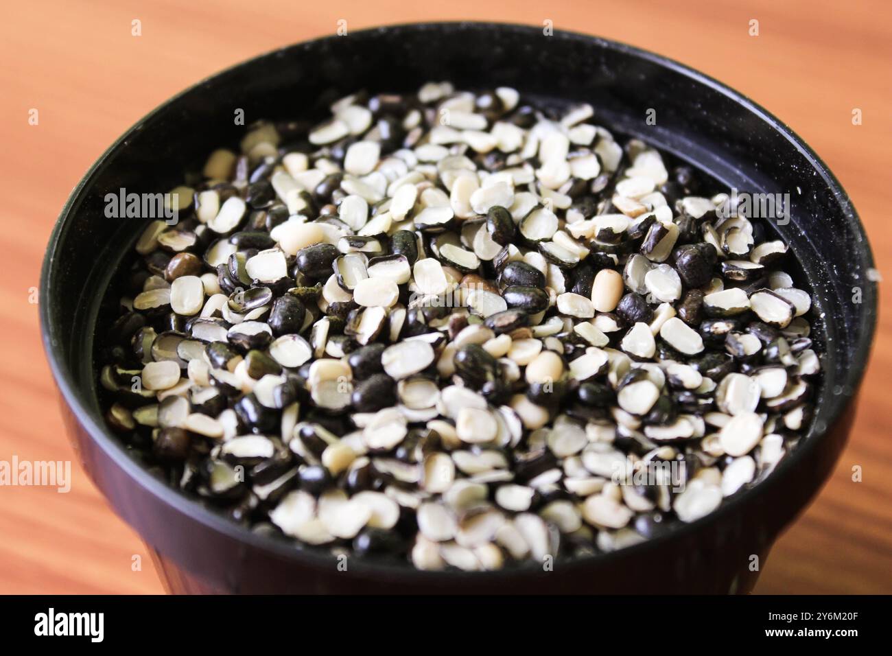 Split Black Lentil également connu sous le nom de Black Gram, Black urad Dal, Vigna Mungo, urad Bean sur fond de bois brun Banque D'Images