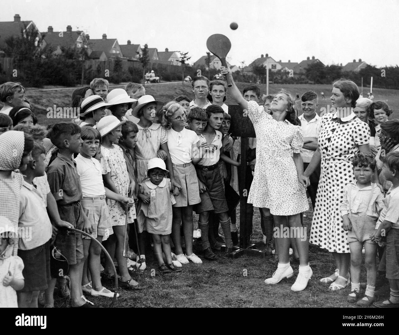 Le conseil de Chislehurst-Sidcup a engagé Miss J. M. Roffey comme instructrice de leadership de jeu pour divertir les enfants en vacances à Sidcup. C'est la deuxième année que l'expérience est essayée, et elle a certainement pour effet d'empêcher les enfants de circuler sur les routes. La photo montre Miss Roffey enseignant le stoolball des enfants, un vieux jeu de Kentish - 10 août 1938. ©TopFoto Banque D'Images