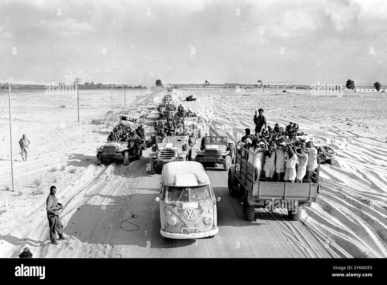 Guerre des 6 jours El Arish, Egypte : les prisonniers égyptiens, les mains au-dessus de la tête, sont transportés au camp, tandis qu'une colonne blindée israélienne se déplace dans la direction opposée près d'ici ce matin. 8 juin 1967 Banque D'Images