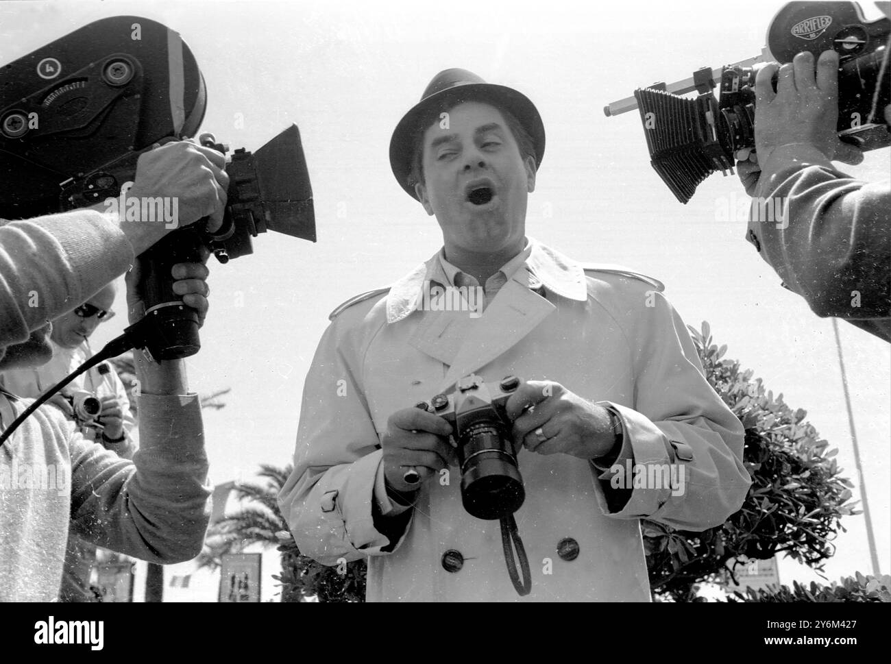 « OK... c'est assez proche, c'est mon tour maintenant ». Le comédien américain Jerry Lewis dans une position amusante avec les cameramen de cinéma à son arrivée à Cannes. Il assiste au célèbre Festival de Cannes. Mai 1967 Banque D'Images