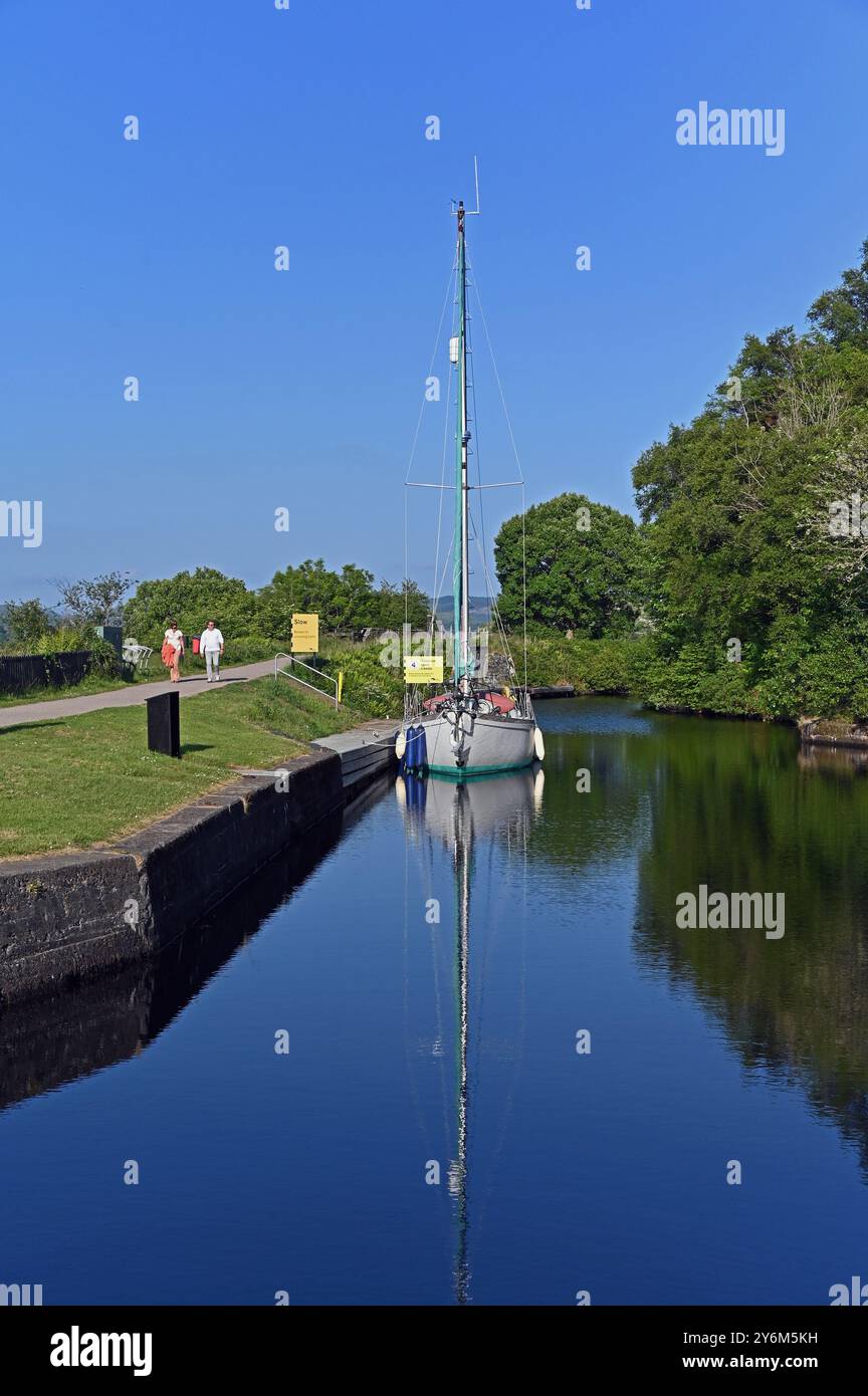 Promeneurs et yacht. Canal de Crinan, Argyll et Bute, Écosse, Royaume-Uni, Europe. Banque D'Images