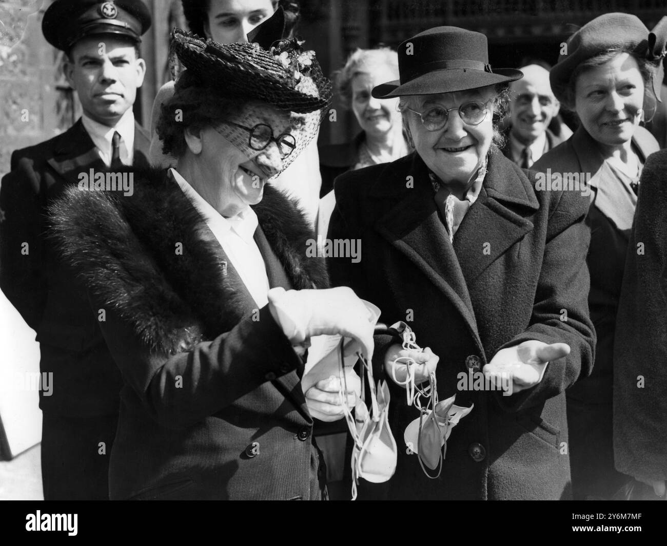 Maundy Money Mme E A Richards, âgée de 89 ans, de Westminster, est vue montrant le Maundy Money que wh a reçu à l'abbaye de Westminster aujourd'hui jeudi Maundy à un autre heureux récipiendaire. Cette année, l'argent royal wnet à 54 hommes et femmes alors que sa Majesté le Roi en est à sa 54e année. 14 avril 1949 Banque D'Images